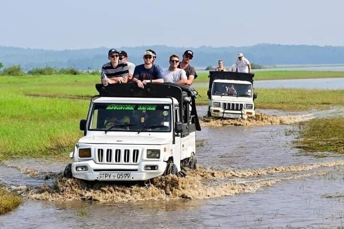 eine Gruppe von Menschen, die auf dem Dach eines Jeeps fahren