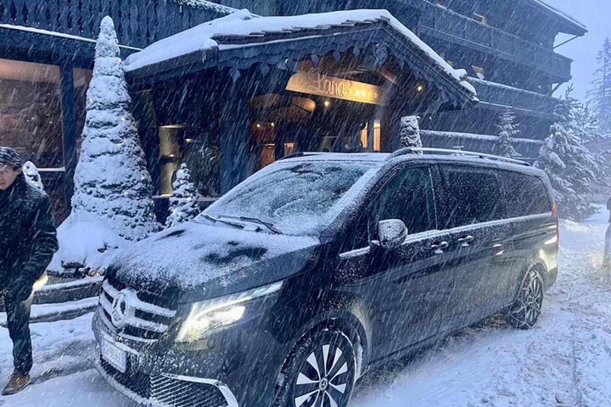 un home dret al costat d'un cotxe a la neu