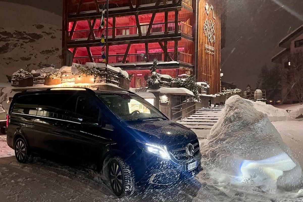 un cotxe aparcat a la neu davant d'un edifici