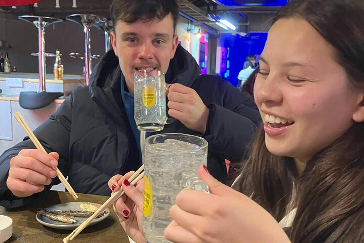 a man and a woman sitting at a table with a drink