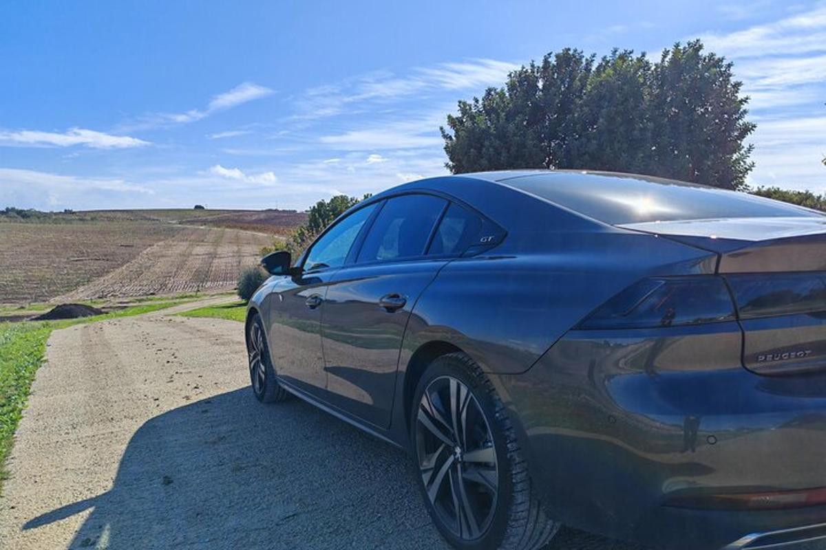 a blue car parked on the side of a dirt road