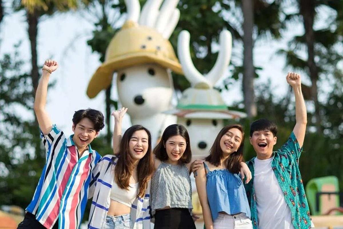 a group of young people standing in front of a statue