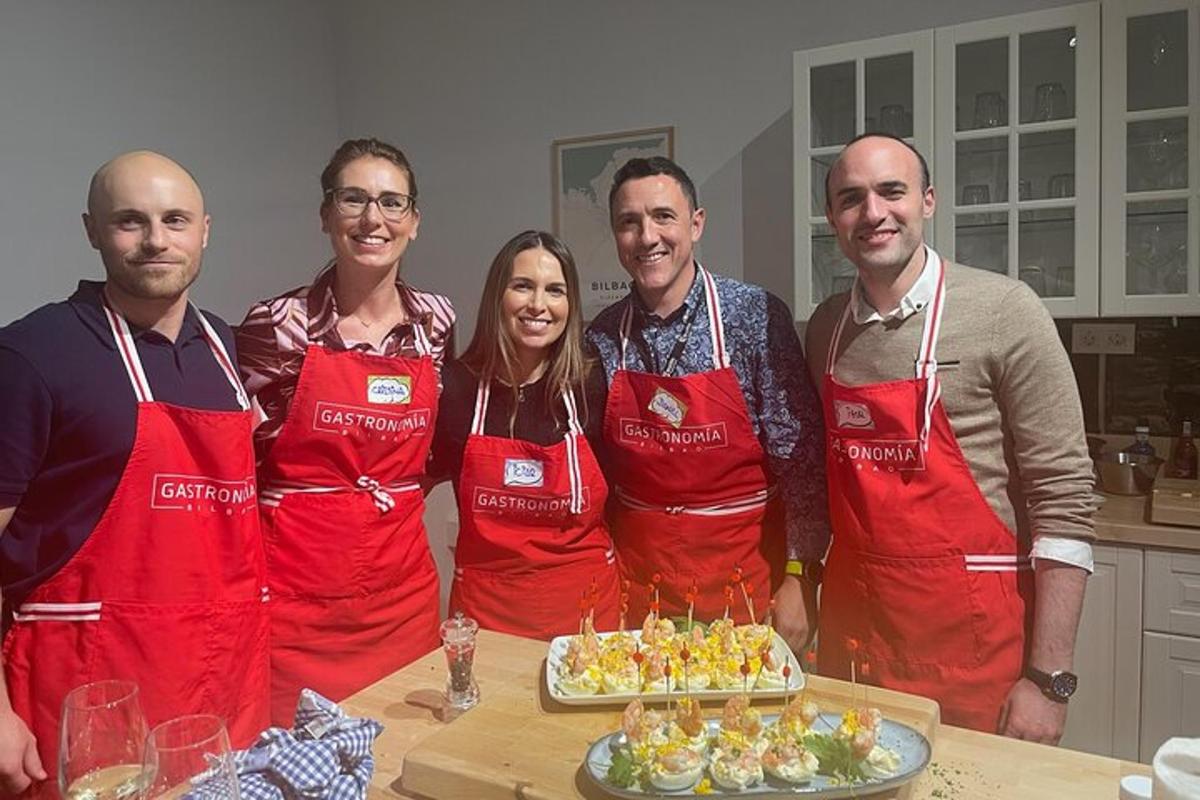 a group of people wearing red aprons in a kitchen