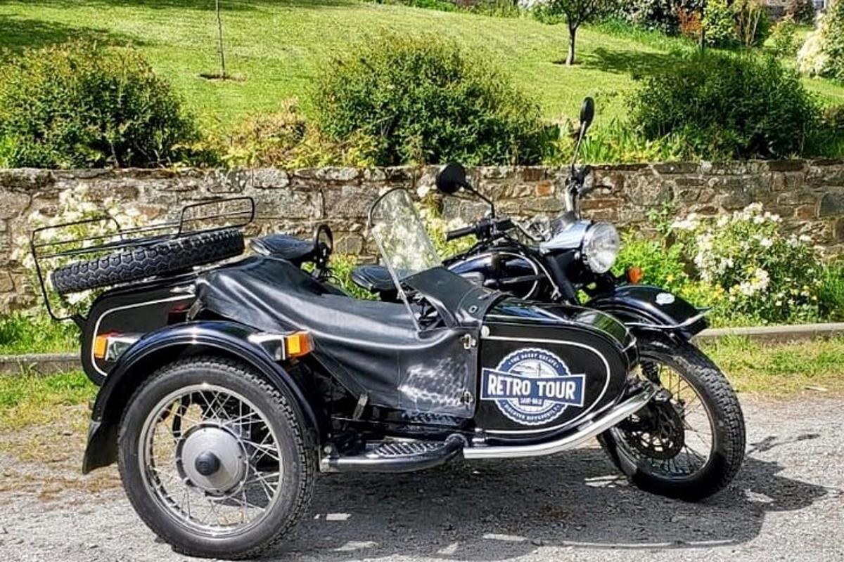a black motorcycle parked next to a stone wall