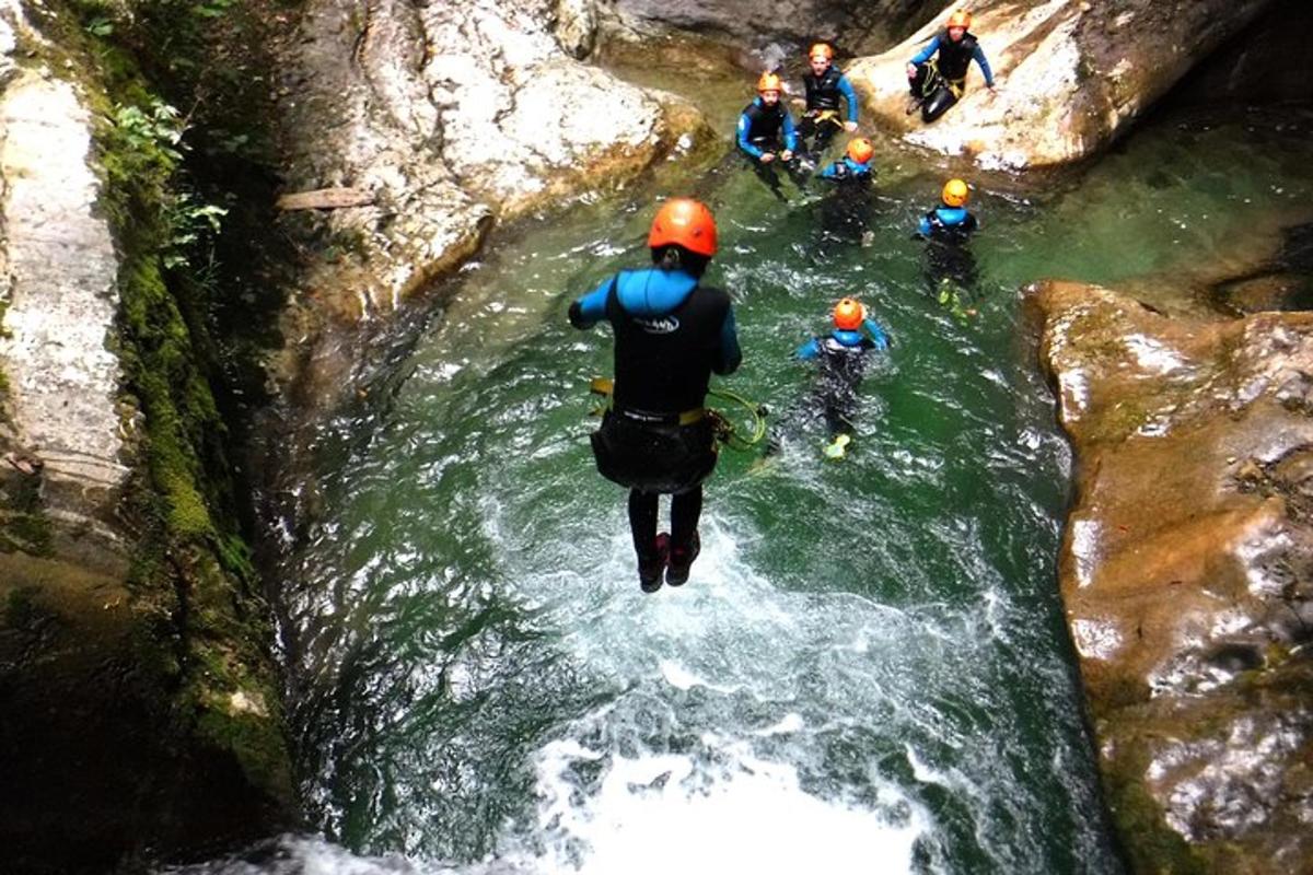 a person jumping into a river with a group of people