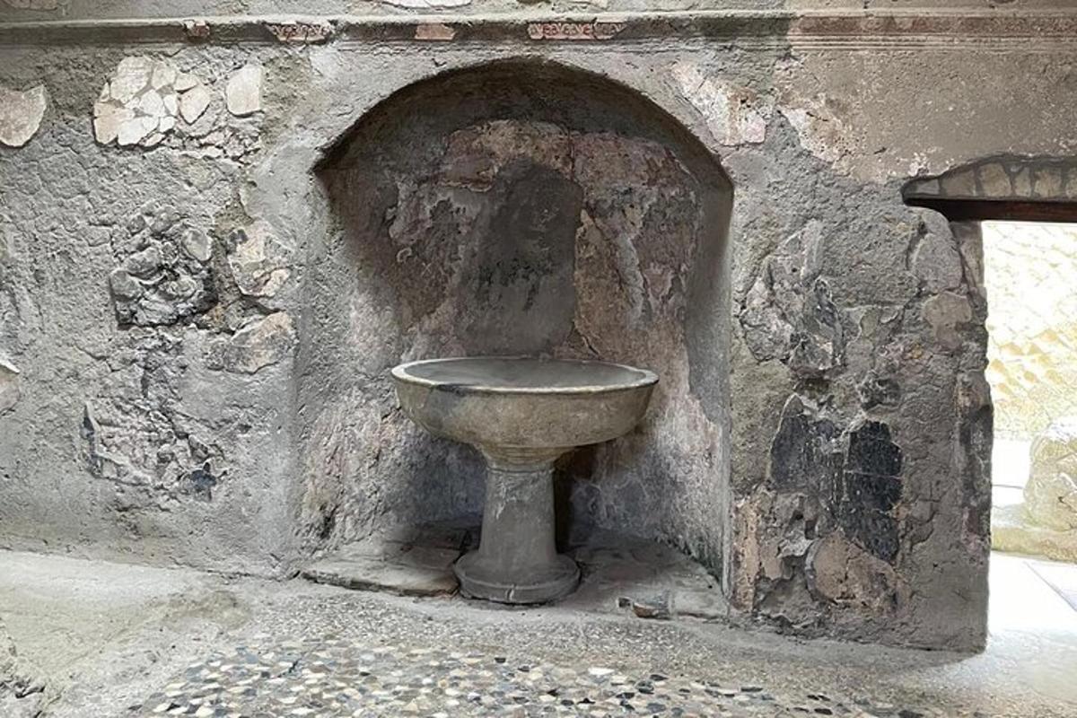 uma pia de pedra no canto de uma parede de pedra