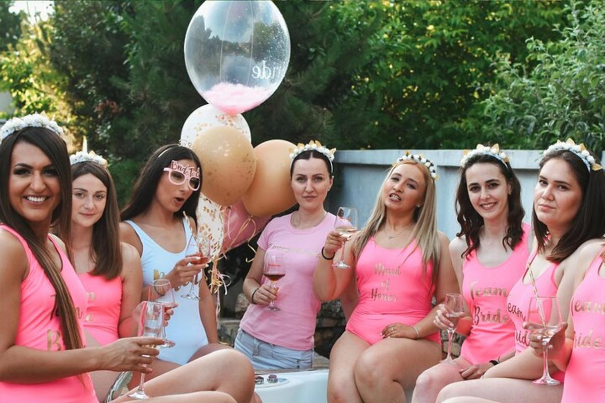 a group of women in pink shirts holding wine glasses