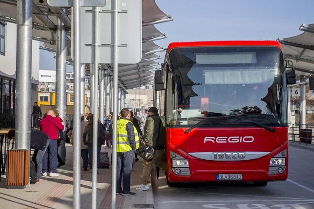 Un autobús rojo está estacionado en una parada de autobús.