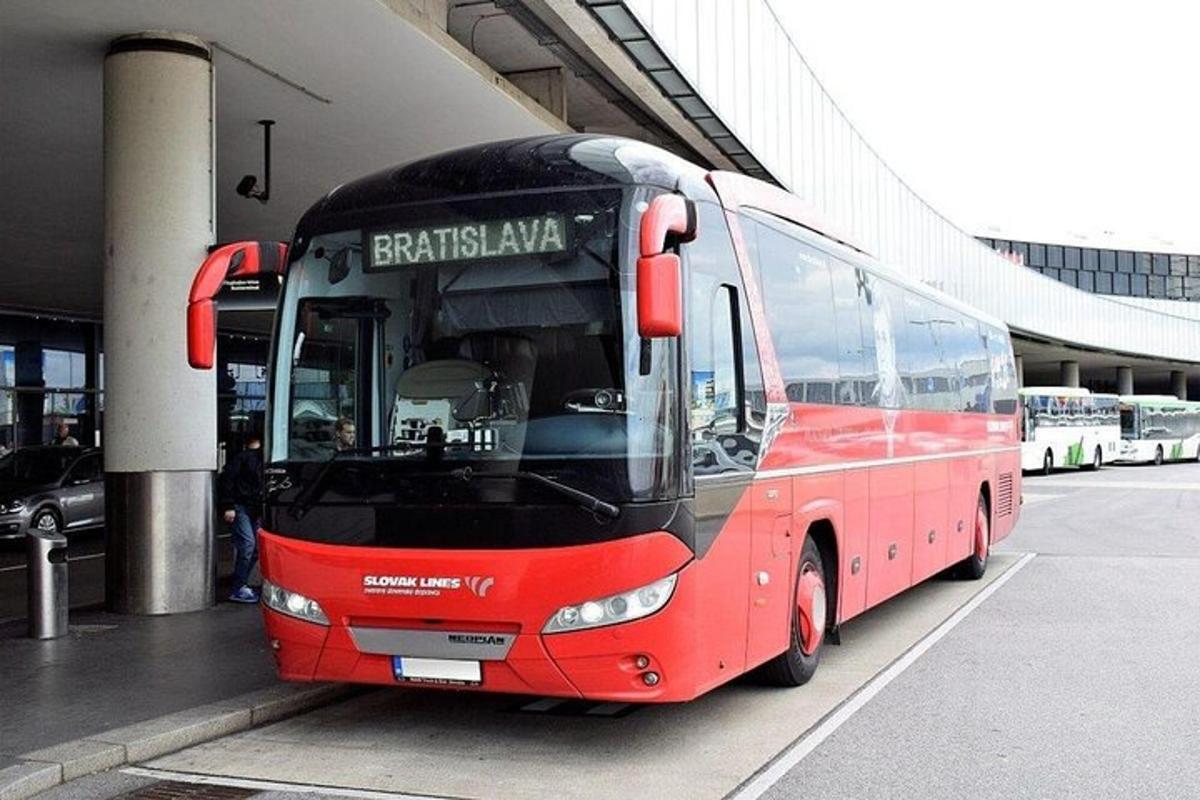 Egy piros busz parkol egy épület mellett