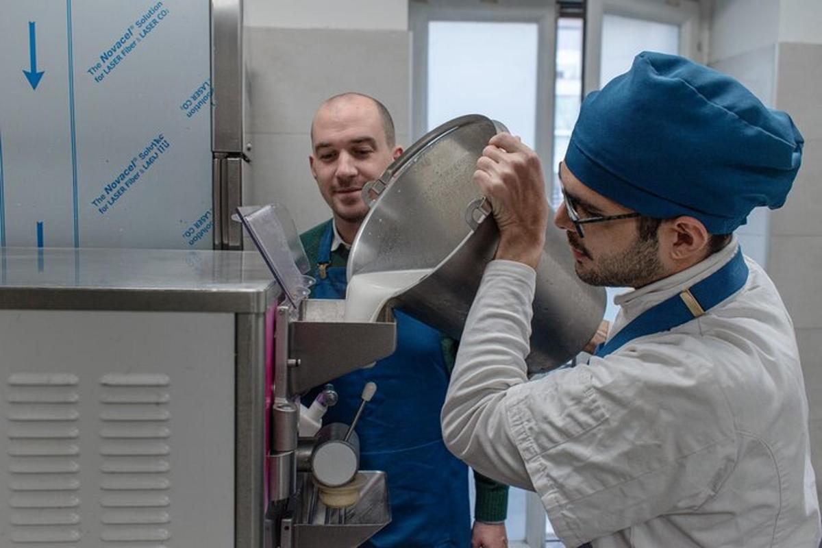 Dos hombres en una cocina preparando comida en una máquina.