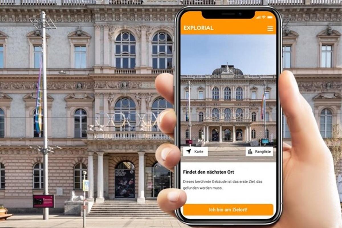una persona che tiene in mano un telefono cellulare davanti a un edificio