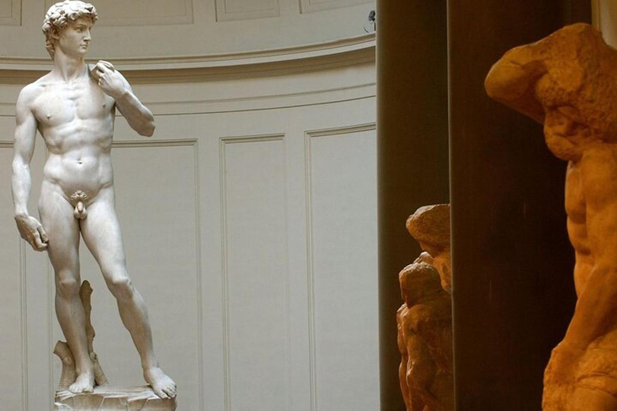 uma estátua de um homem em um museu com um ursinho de pelúcia