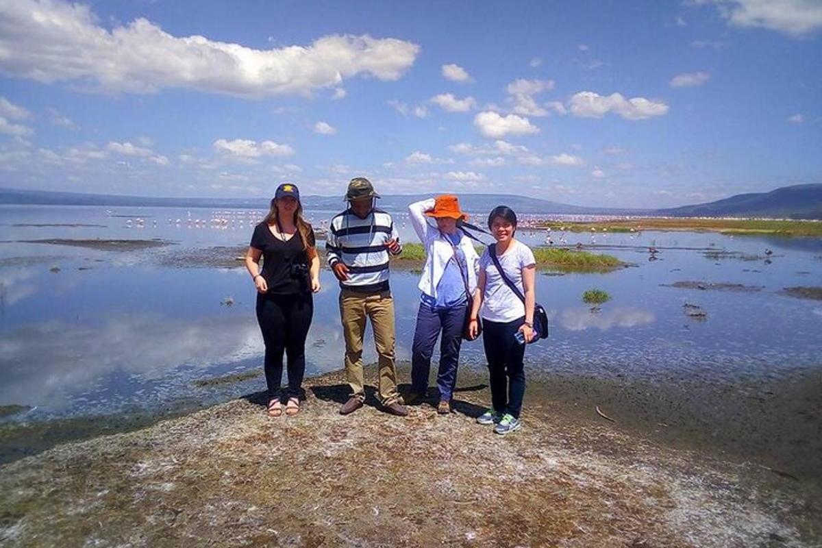 isang grupo ng mga tao na nakatayo sa isang bato malapit sa tubig