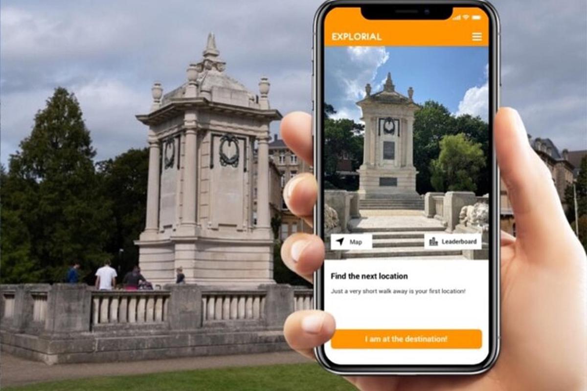een persoon die een mobiele telefoon omhoog houdt voor een monument