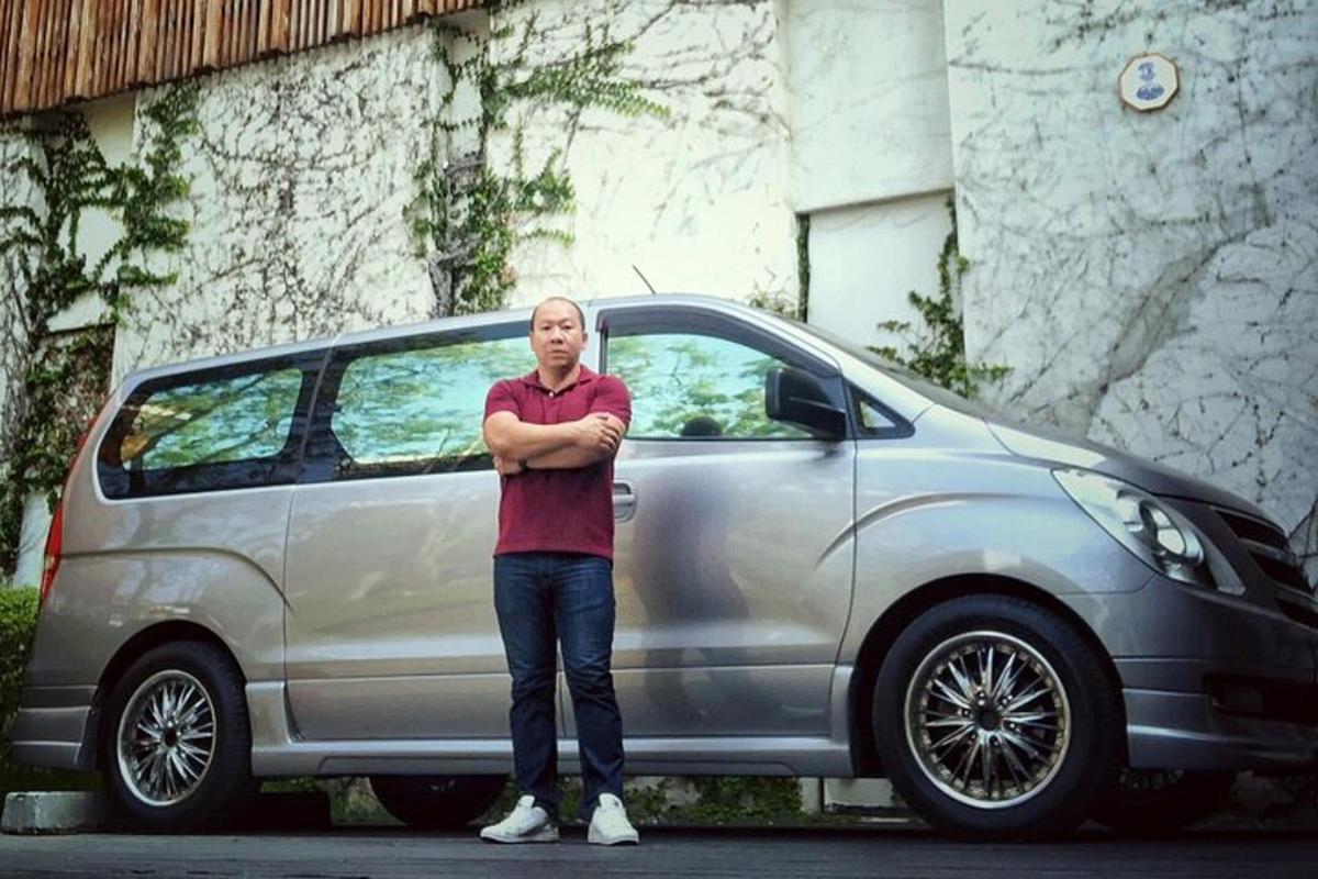 muž stojící před stříbrným autem