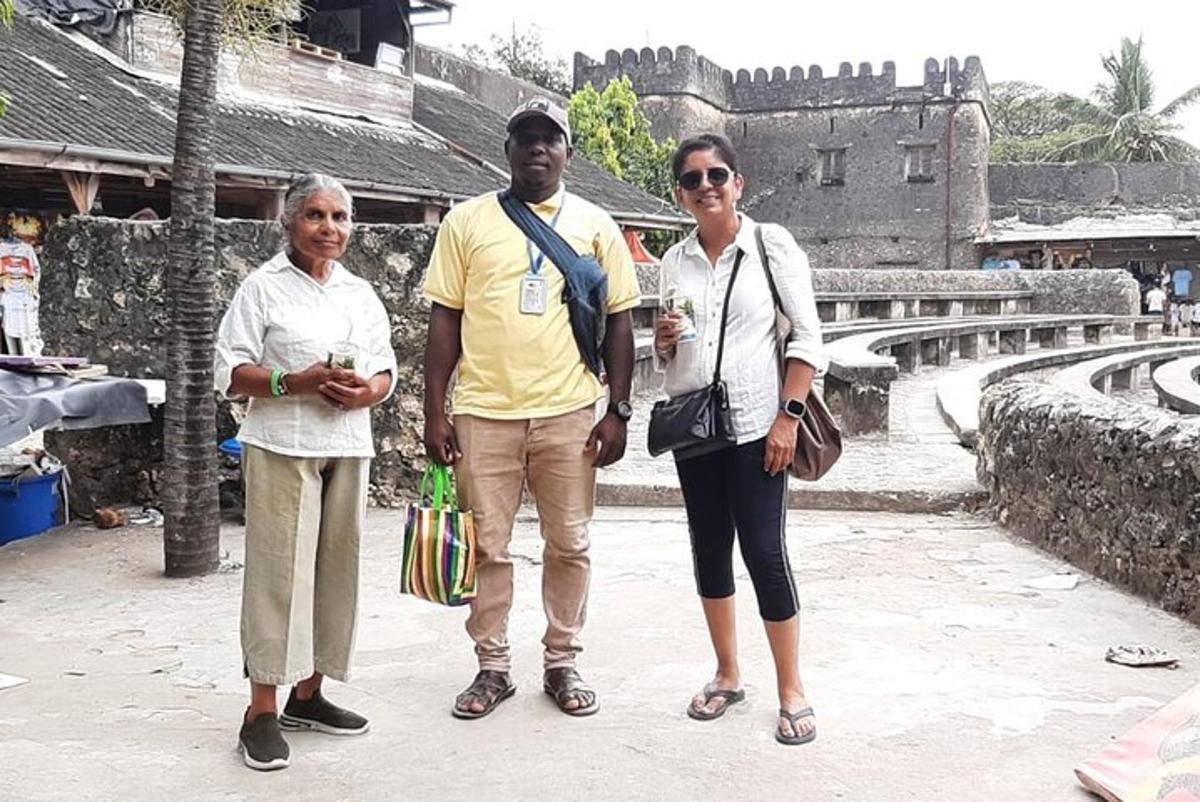 um grupo de três pessoas em pé em frente a um castelo
