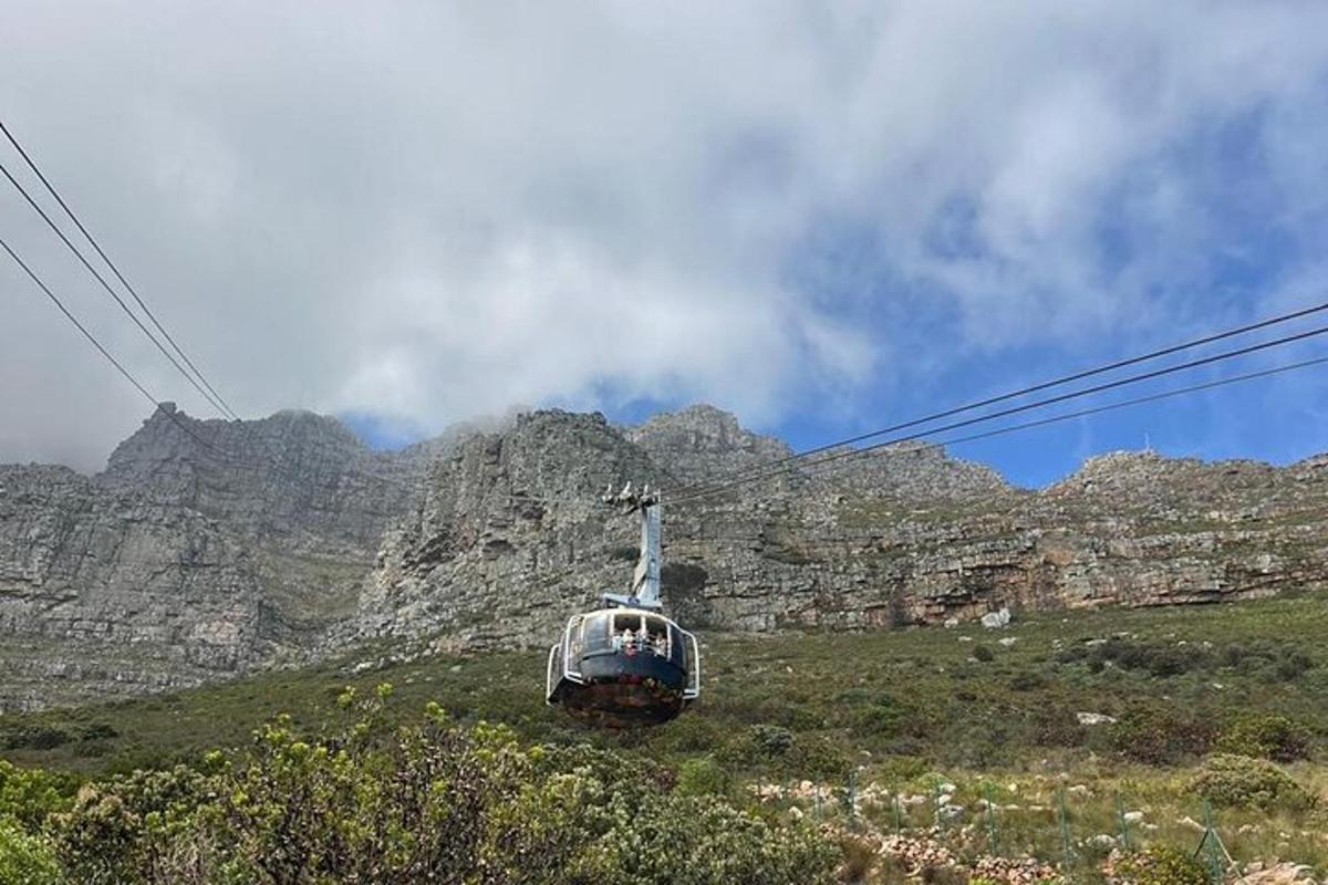 un téléphérique sur une colline avec des montagnes en arrière-plan