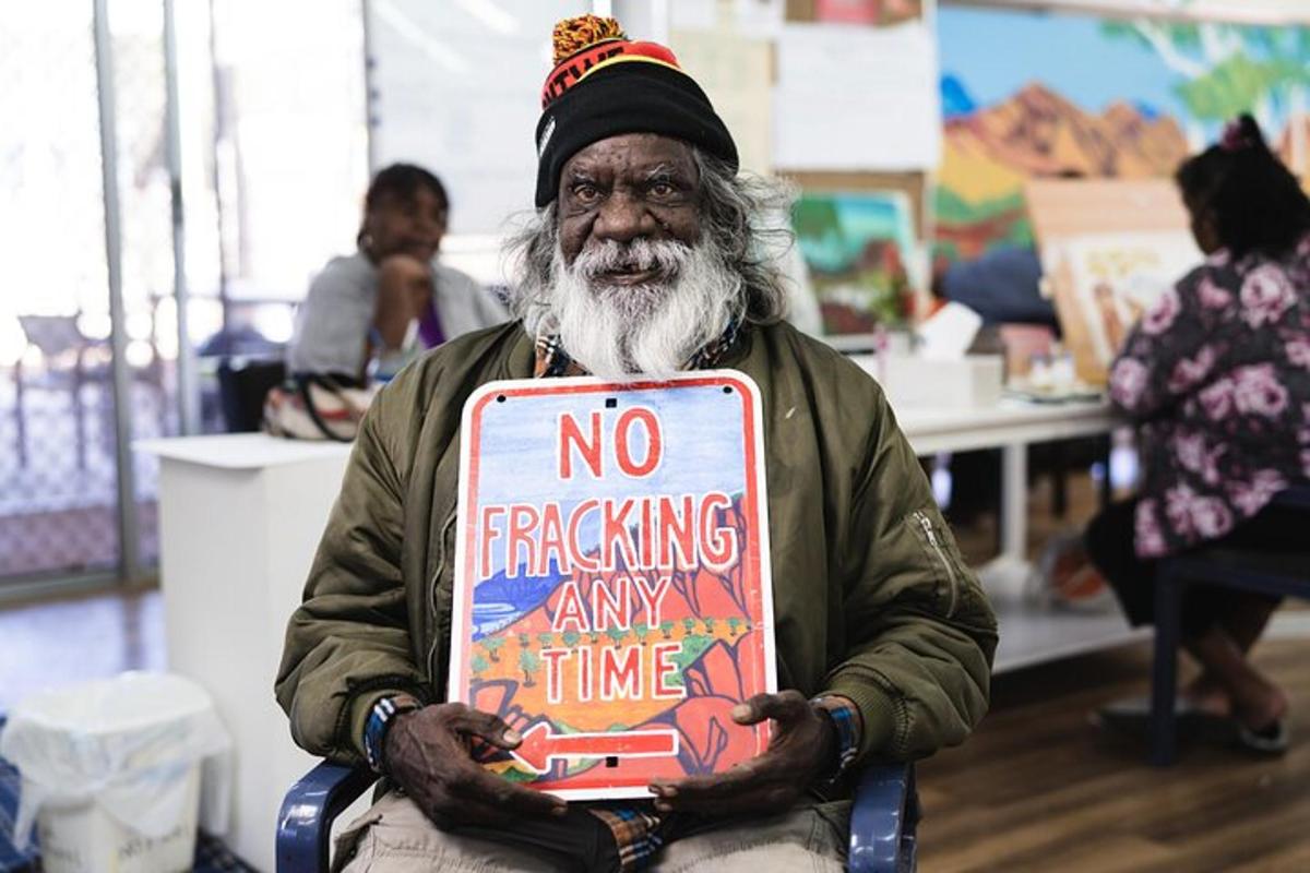 a man holding a sign that says no offending any time