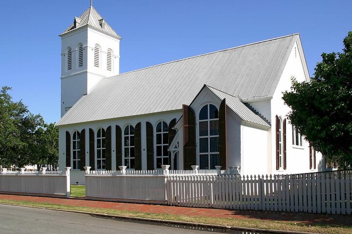 a white church with a white fence in front of it