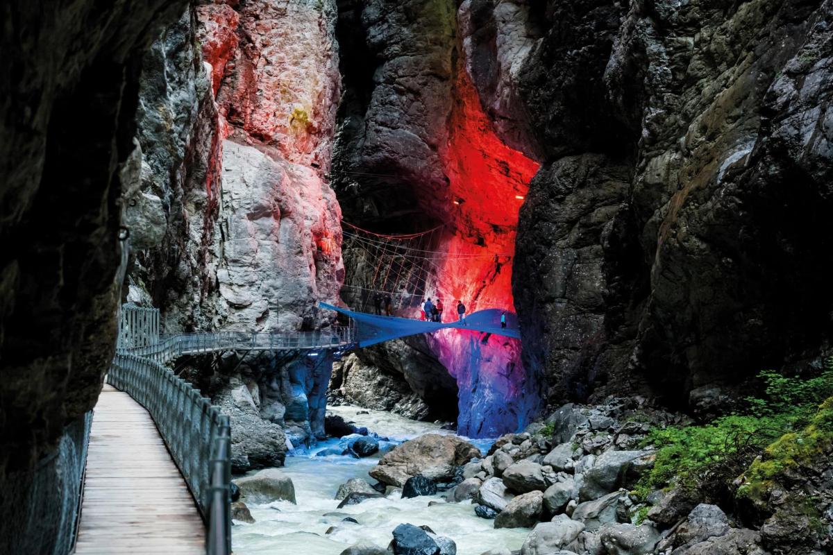 a pathway in a cave with a colorful wall