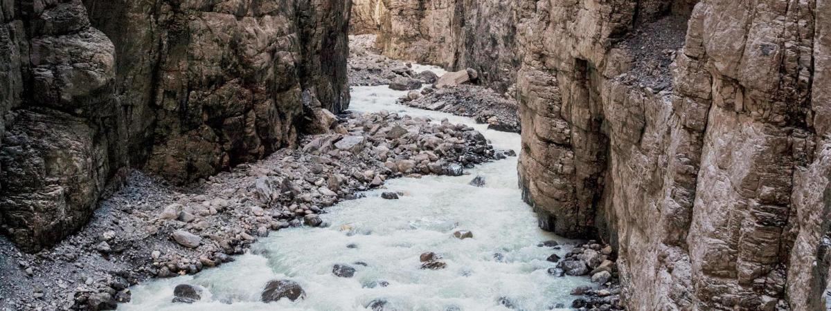 a stream of snow and rocks in a canyon