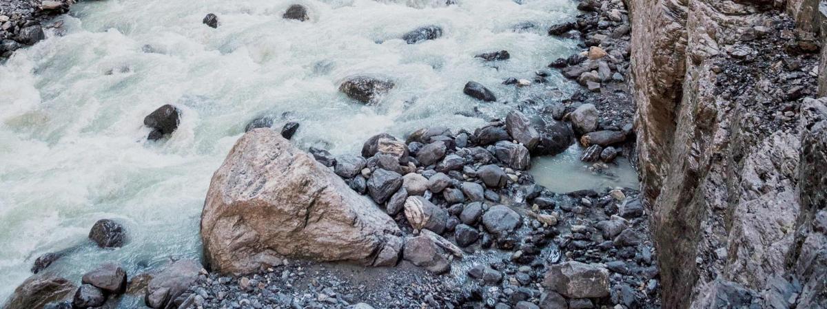 a river with snow and rocks in the water