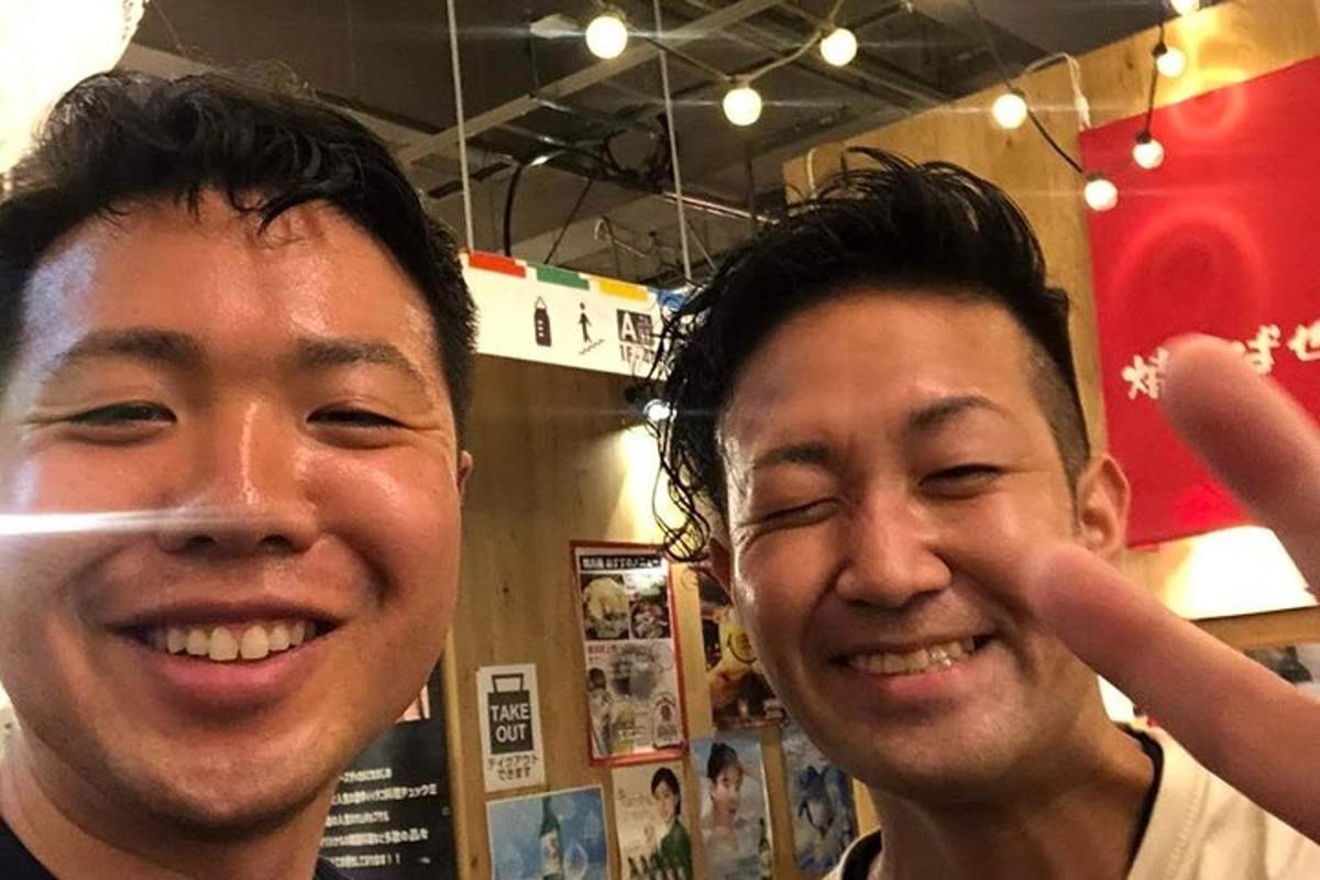 due uomini posano per una foto mentre sorridono