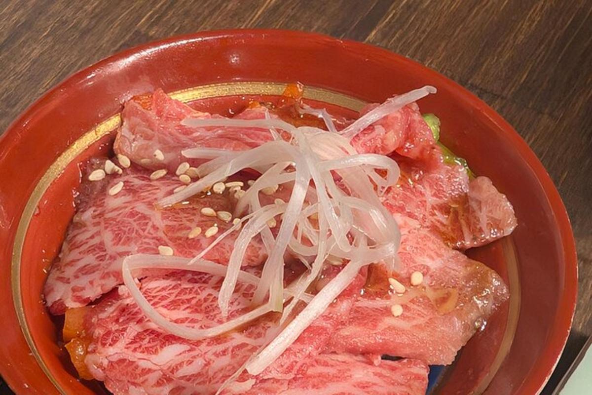 una ciotola di cibo con carne e cipolle sopra