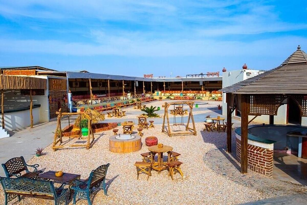 Un patio al aire libre con mesas y sillas y un parque infantil.