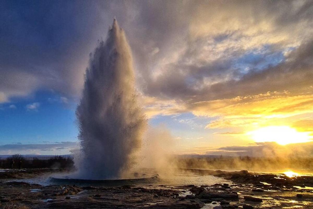 un geyser in mezzo a un campo con un tramonto
