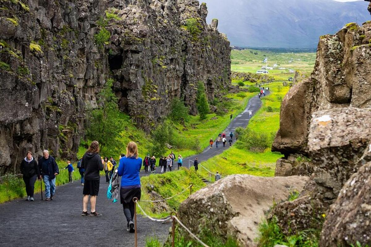 Un grupo de personas caminando por un sendero entre rocas.