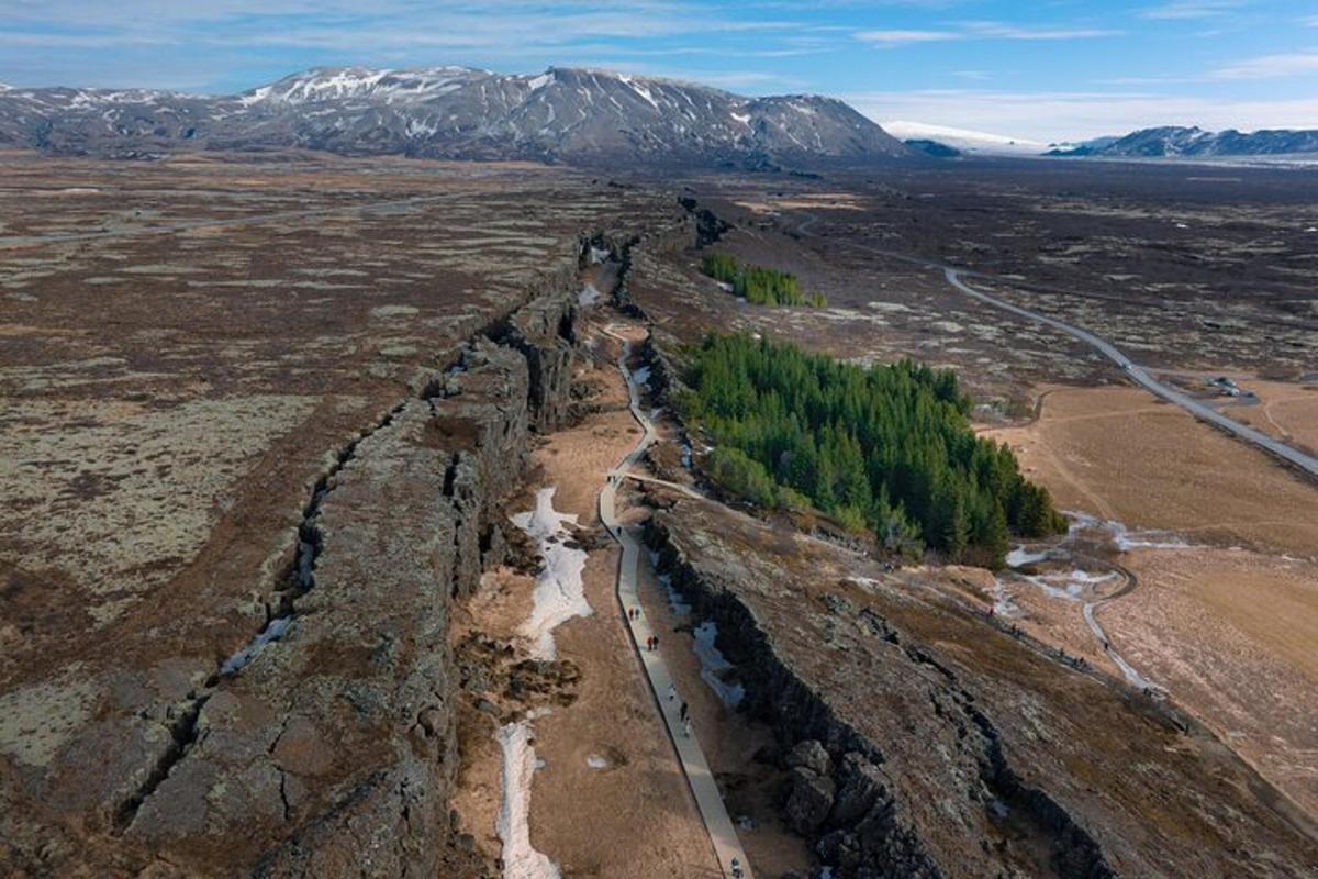una vista aerea di un fiume in un campo con montagne