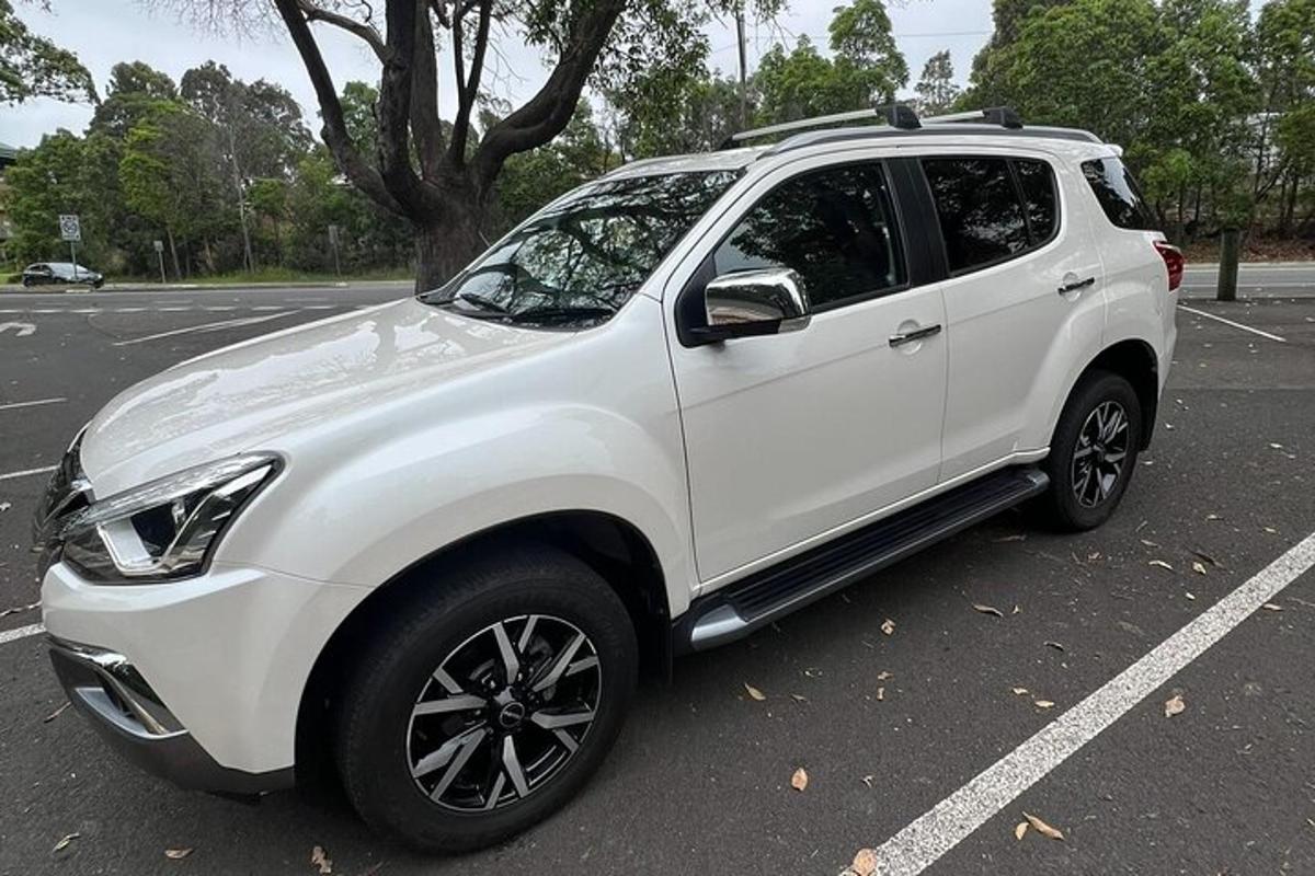 ein weißer SUV auf einem Parkplatz geparkt