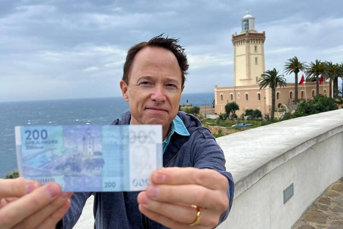 mees, kes hoiab käes dollariraha
