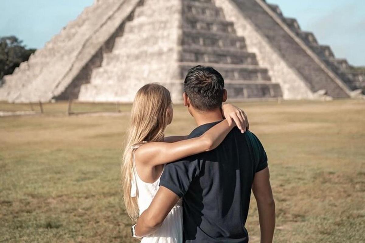 a man and a woman standing in front of a pyramid