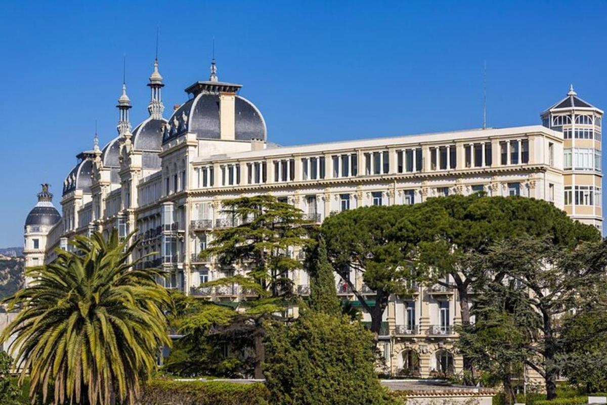 un grande edificio bianco con alberi di fronte