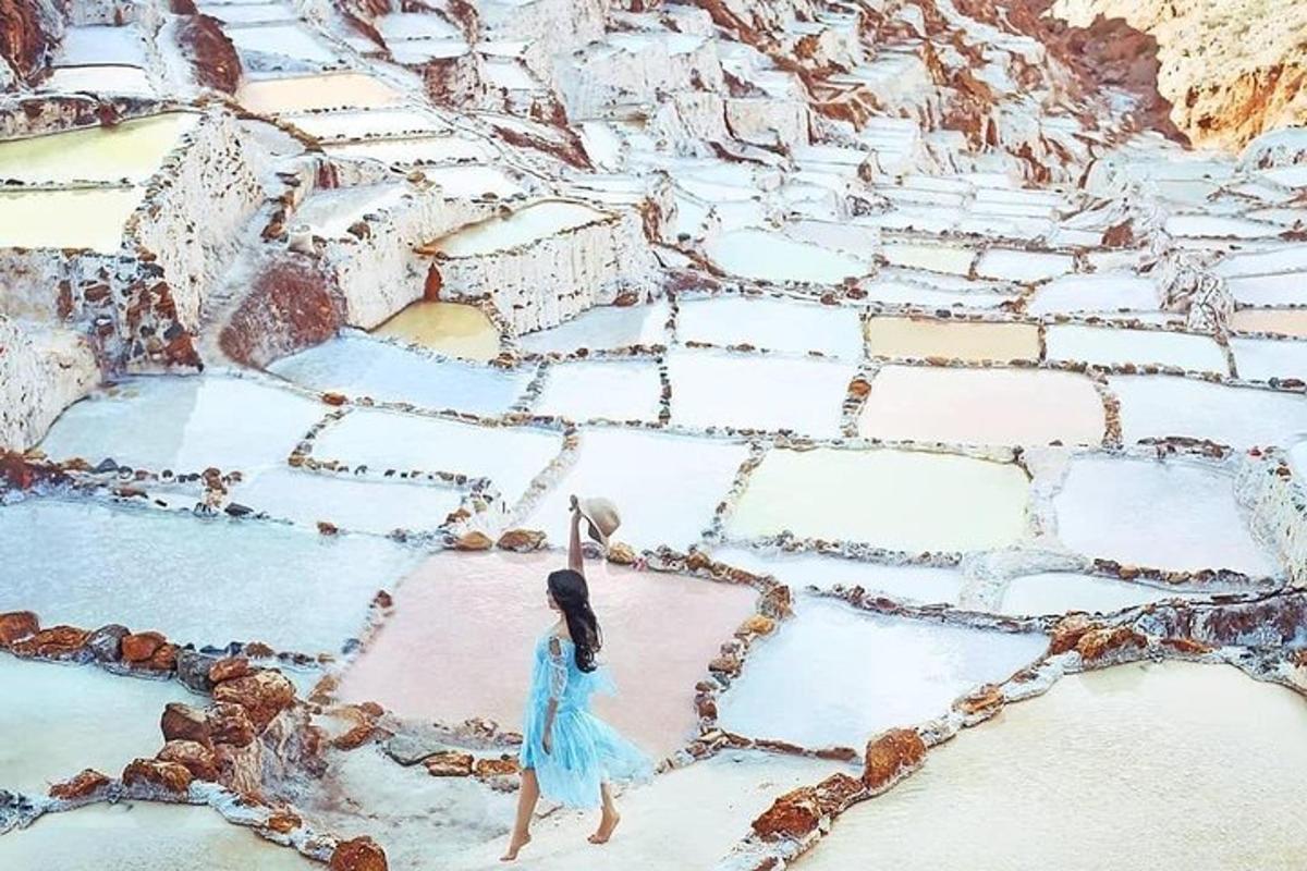 uma mulher de vestido azul caminhando em uma passarela de pedra