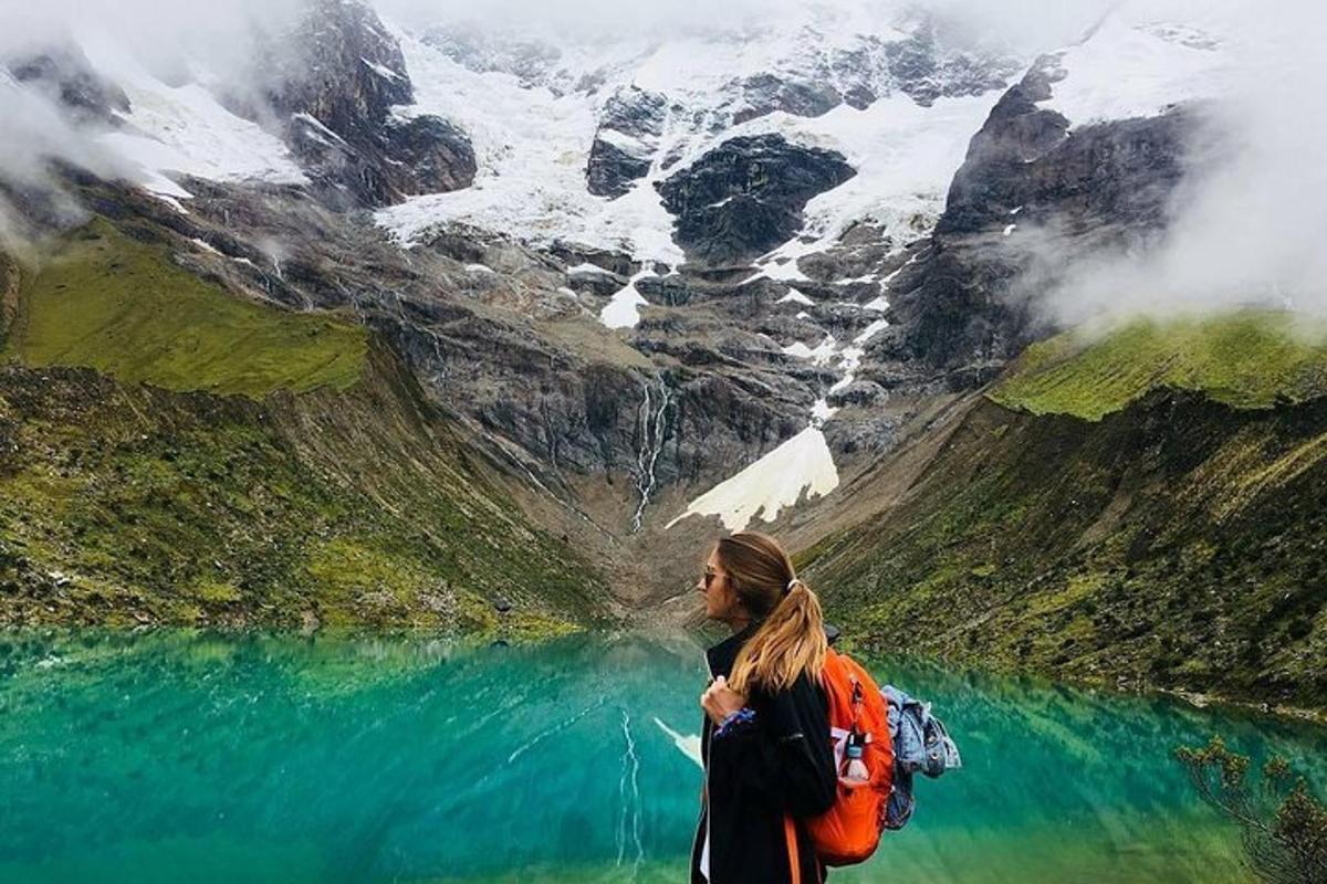 una donna in piedi di fronte a una montagna con un lago
