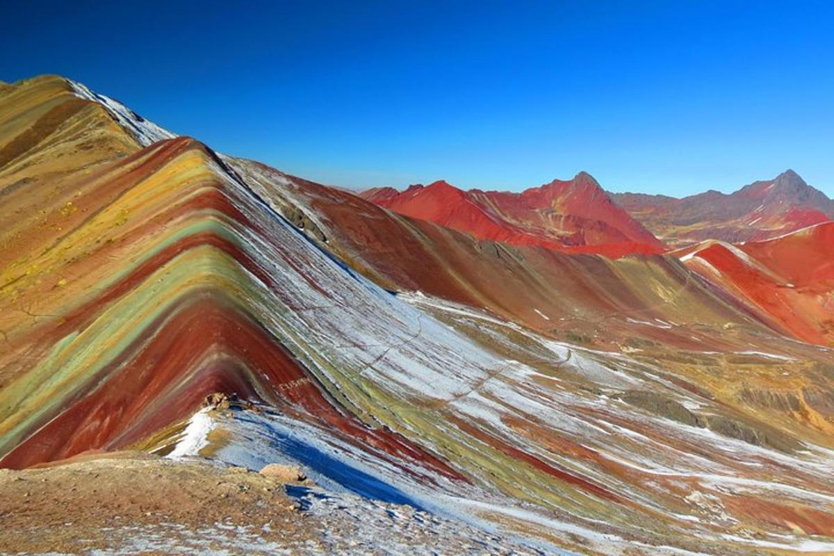 a painting of a mountain with rainbow colors