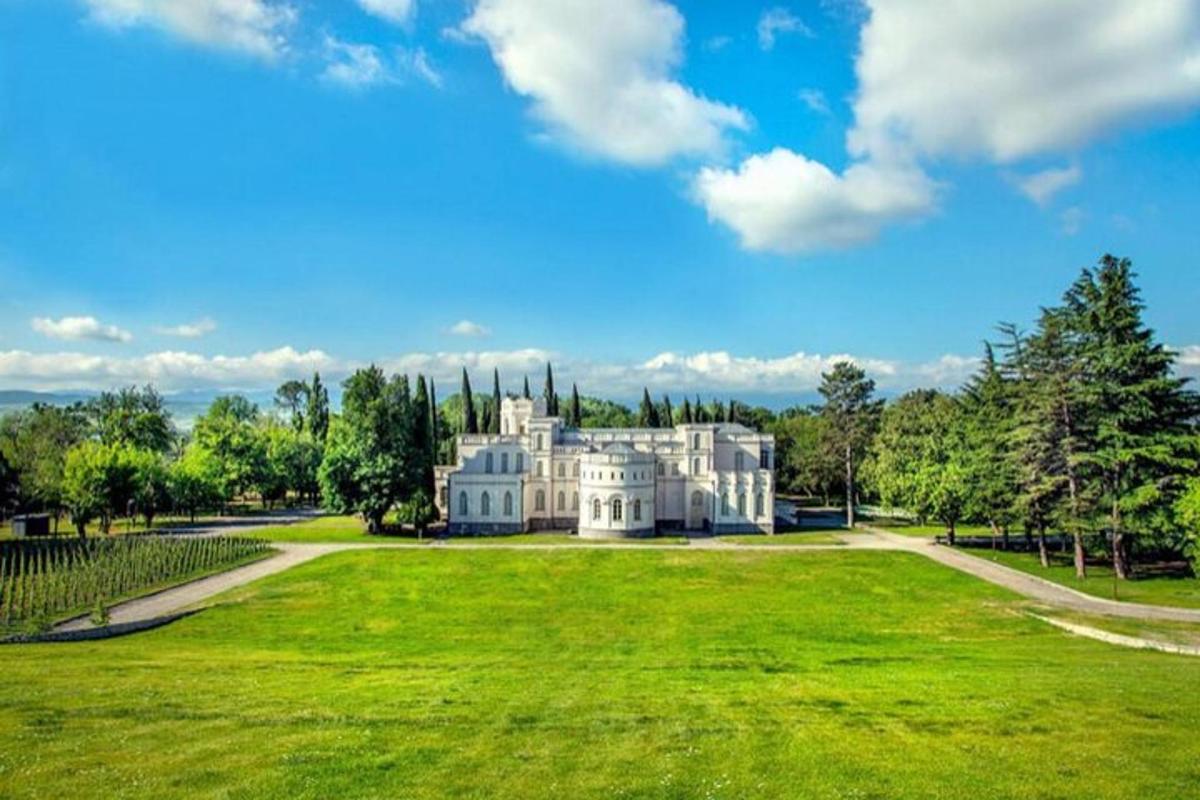 Una gran casa blanca en un exuberante campo verde