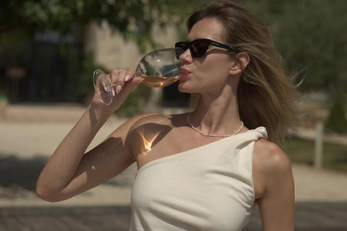 kona með sólgleraugu að drekka glas af víni