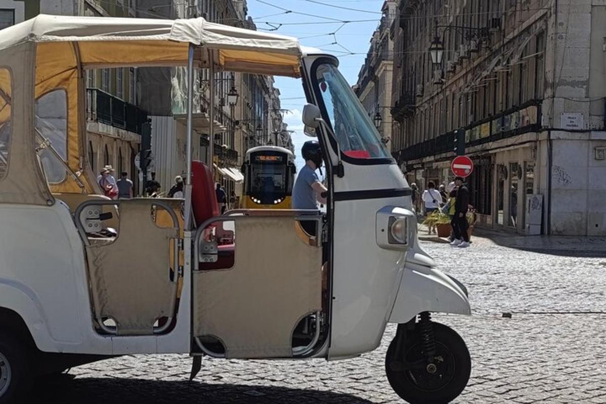 Un pequeño carrito de golf blanco estacionado en una calle