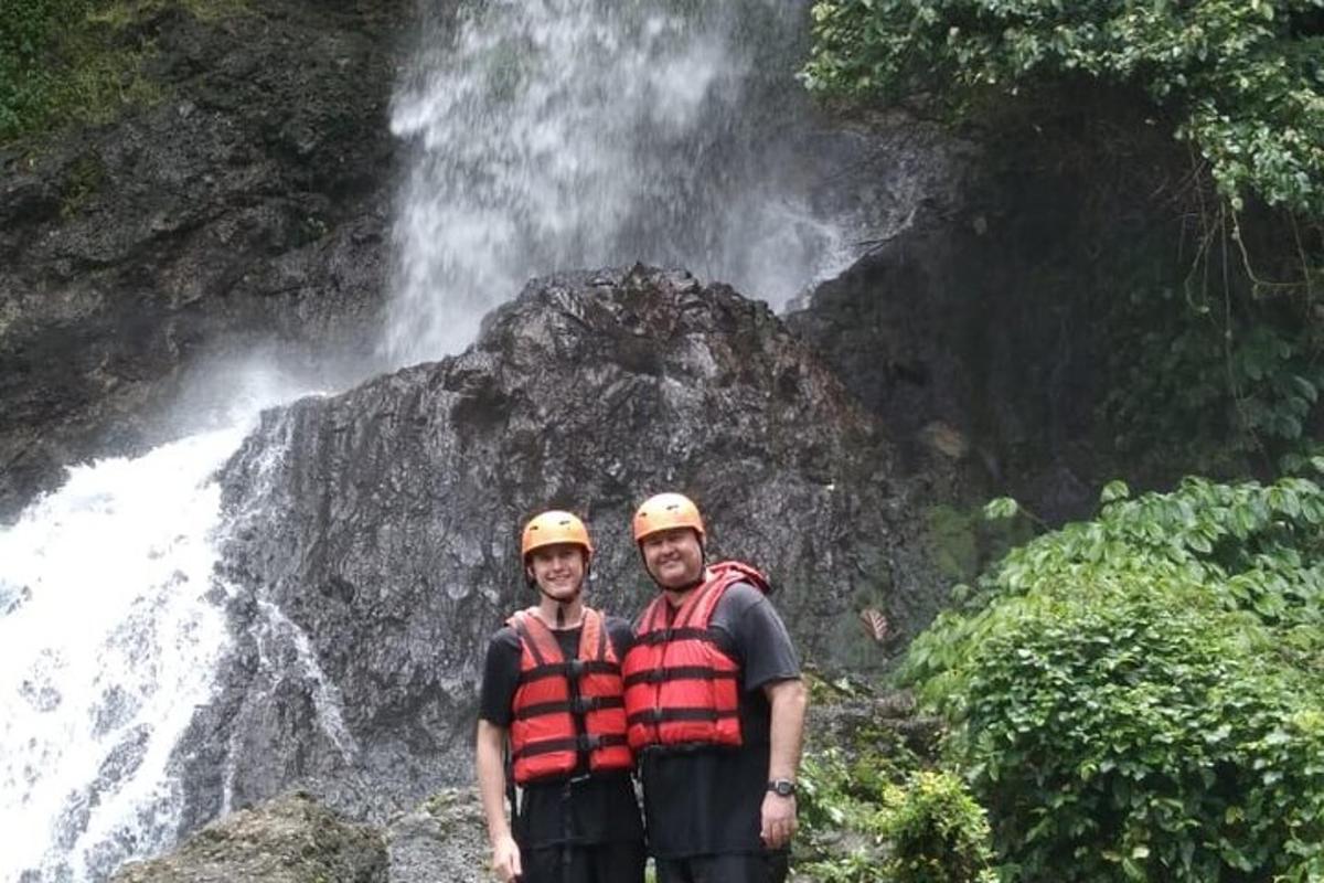 due persone che indossano giubbotti di salvataggio in piedi davanti a una cascata