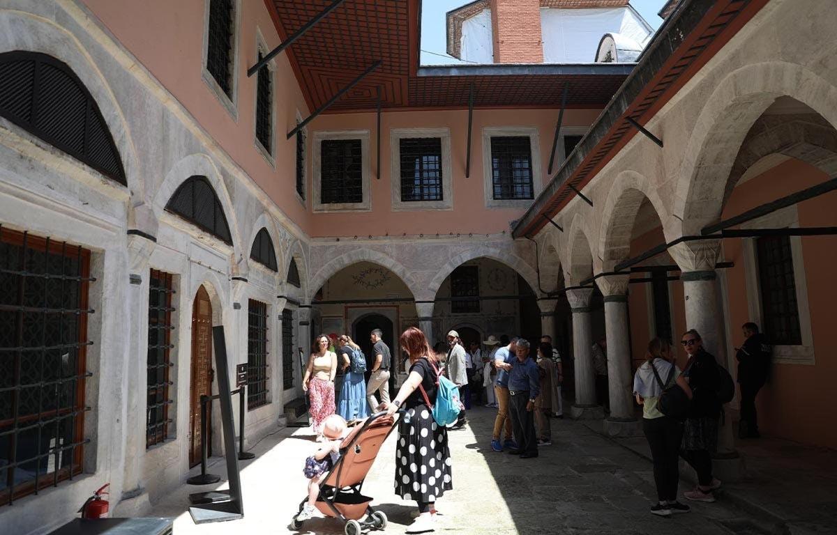 Μια γυναίκα που κρατάει ένα παιδί στην αυλή ενός κτιρίου