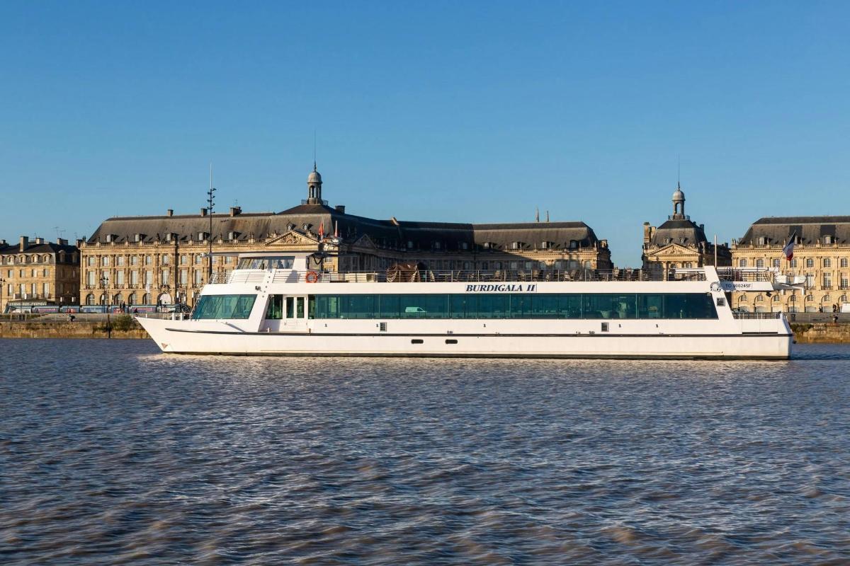 a white boat in the water in front of buildings