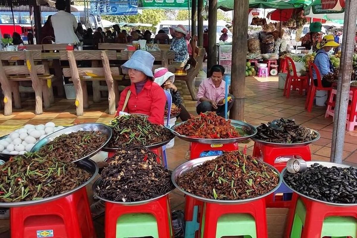 Una mujer parada en un mercado con un montón de comida.