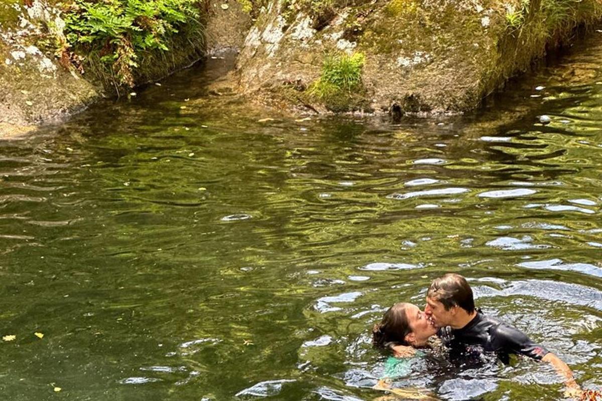 um homem e uma mulher estão se beijando na água