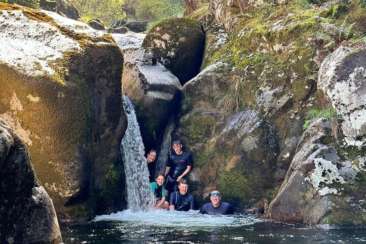 un gruppo di persone in acqua vicino a una cascata