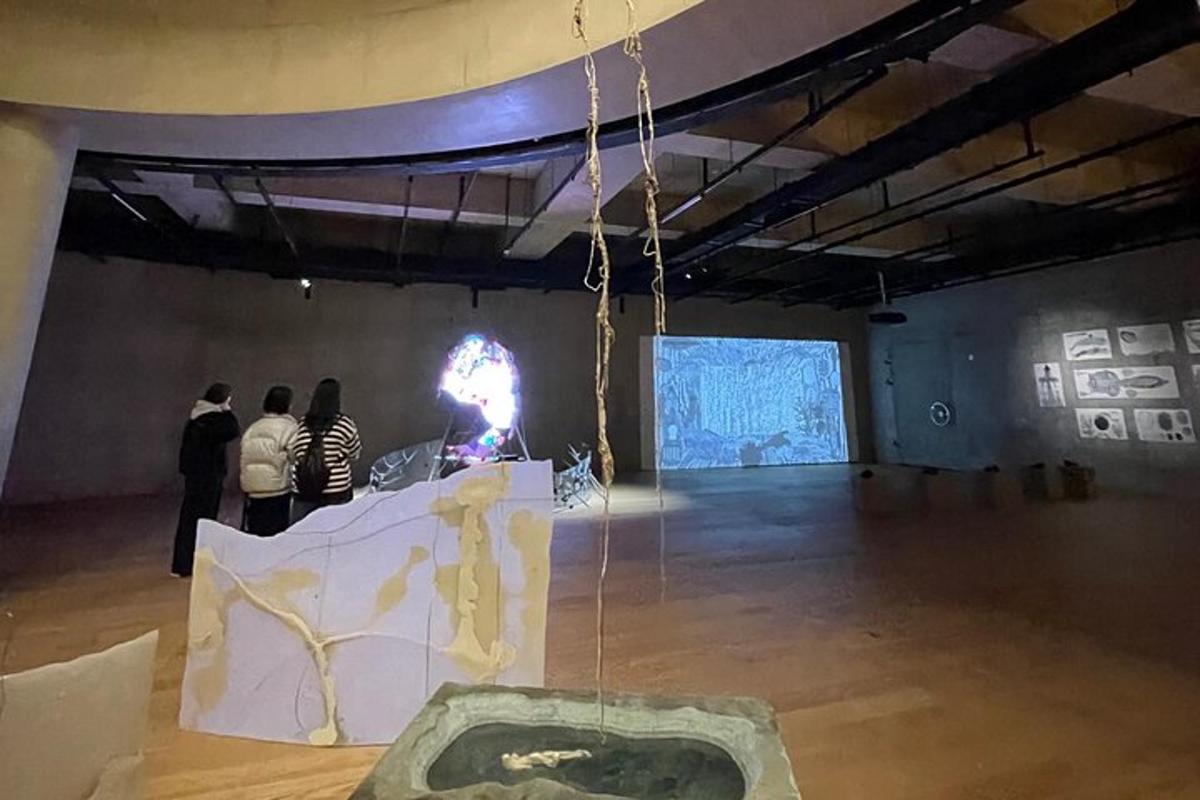 um grupo de pessoas em pé em uma grande sala com uma exposição