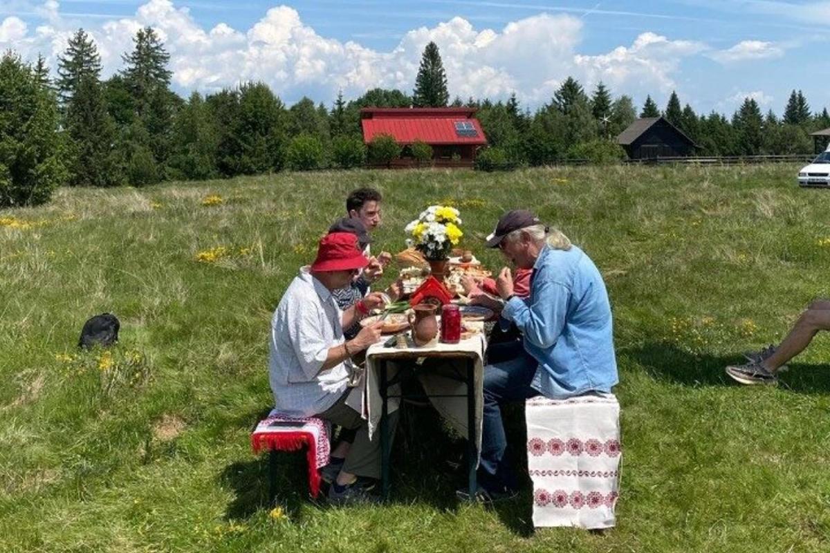 skupina lidí sedících u stolu na poli